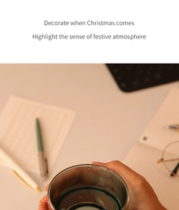 Close-up of double-walled glass cup with Christmas holiday patterns and warm office background