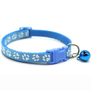 Close-up of light blue pet collar with white paw prints and blue bell for cats