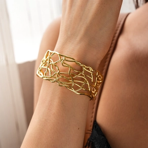 Macro view of wide 18K gold plated hollow mesh bracelet featuring an irregular woven design