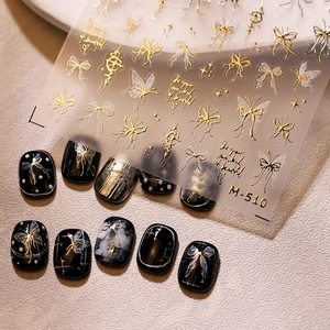 Stickers à ongles papillon dorés 3D avec motifs de nœuds et d'étoiles sur ongles noirs