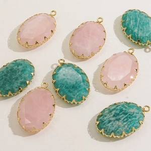 Detail of oval faceted natural stone pendants with gold-plated stainless steel settings
