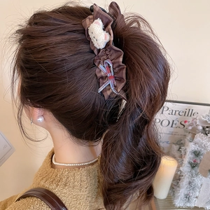 Vue détaillée de la pince à cheveux à carreaux marron avec nœud et ours en peluche