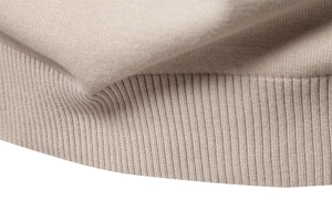 Gros plan sur la maille du pull kaki montrant les poignets côtelés et le tissu doux