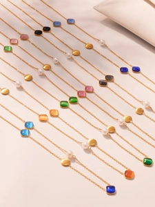 Detail von bunten Regenbogenperlen auf goldener Edelstahlkette mit Perlen und Metallscheiben