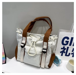 Detailed view of cream and brown contrast tote bag with drawstring and pockets