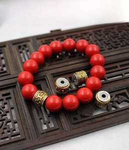 Macro detail of Buddhist mantra beads and red cinnabar stones on a wooden tray