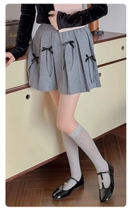 Detailed close-up of grey calf socks with back ribbon bows and elegant balletcore style