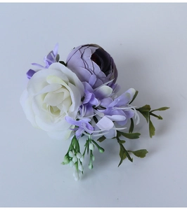 Detail of white rose and lilac silk flower corsage with green leaves and elegant stem