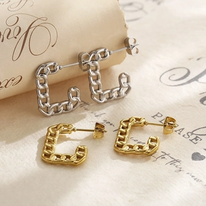 Macro view of geometric Cuban chain earrings in gold and silver metallic finishes