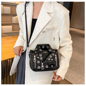 Detail of creative leather jacket bag with silver zippers and white floral appliques