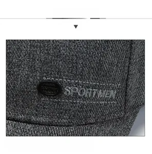 Détail macro de casquette de baseball gris foncé avec broderie SPORTMEN et logo métal
