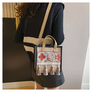 Detailed embroidery and four fringe tassels on ethnic style canvas tote bag with strap