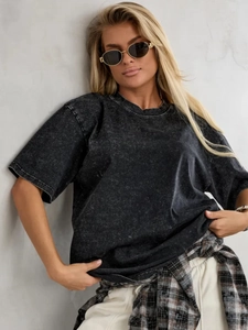 Detail of vintage acid wash texture on a black oversized 100% cotton T-shirt
