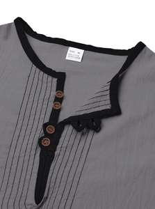 Detail of grey linen shirt neckline with black trim and brown buttons closeup view