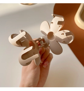 Close-up of beige flower hair claw clip showing durable internal metal spring mechanism