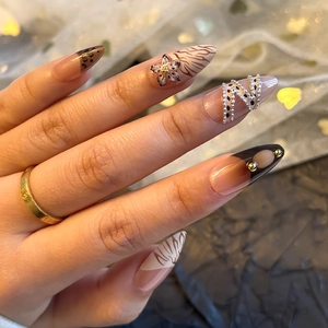 Detail of 3D luxury press-on nails with leopard print and silver chain embellishments