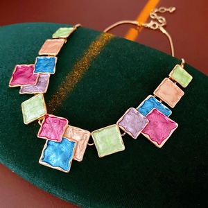 Detail of bohemian geometric square pendant necklace with colorful glazed enamel tiles