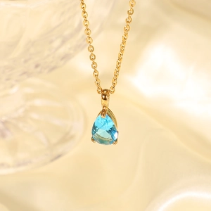 Macro view of pear-cut blue zircon pendant on 18K gold plated stainless steel chain
