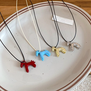 Détail de colliers de chevaux mignons en rouge, bleu, or et argent sur un plateau