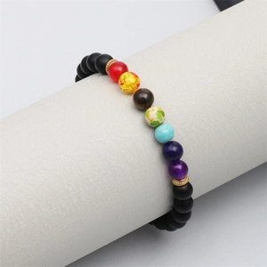 Détail d'un bracelet de perles colorées en pierres d'énergie et perles noires mates dorées