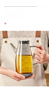 Close-up of a 1000ml glass oil dispenser with stainless steel lid and ergonomic handle
