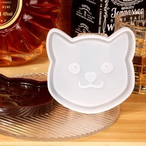 Detailed view of cat-shaped silicone mold with finished resin coaster on a glass tray