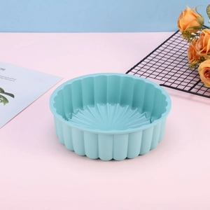 Macro detail of a light blue silicone sunflower cake mold with textured wavy side walls