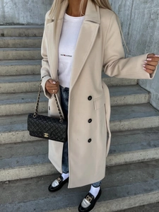 Detail view of double-breasted beige wool coat with lapel collar and contrast black buttons