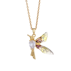 Golden hummingbird necklace with heart crystal and gradient colorful wings on white background
