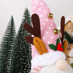 Close-up of plush Christmas gnomes with elk antlers, gold bells, and berry accents