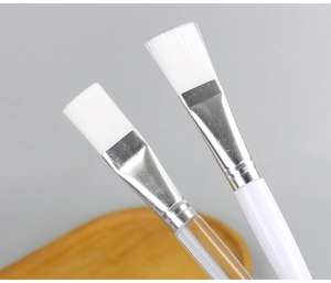Macro view of soft white bristles and transparent crystal handle mask brush