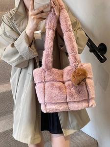 Pink plush quilted tote bag with brown fur pom-pom charm shown on model in khaki coat
