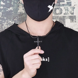 Primo piano di un uomo con una collana a croce in acciaio inossidabile nero stile street