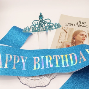 Close-up of sparkling blue rhinestone birthday crown and glitter sash set for parties