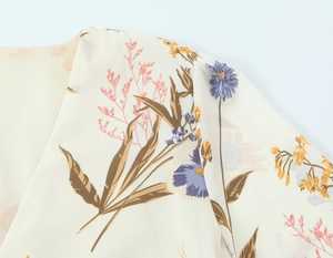 Close-up of floral chiffon dress showing the shoulder seams and V-neckline detail