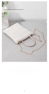 Detailed view of a white plush faux fur crossbody bag with an elegant thin gold chain strap