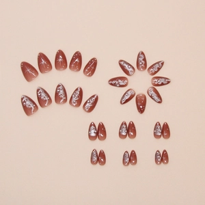 Macro shot of 3D pearls and silver star motifs on almond-shaped gradient press-on nails
