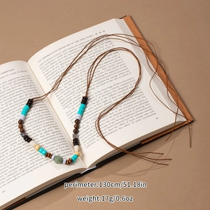 Macro view of multi-color beads on a long bohemian necklace with retro wax rope details
