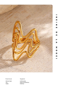 Detailed view of an 18K gold plated irregular wave ring on a textured stone surface