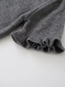 Detailed macro shot of grey knitted fabric texture and elegant ruffle trim design