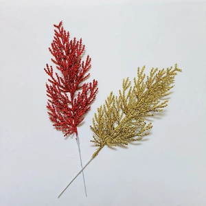 Close-up of glittered Christmas pine branches in festive red and gold for holiday decor