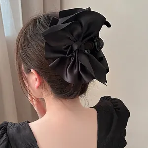 Eleganter großer schwarzer Satin-Haarclip mit Schleife für Dutt-Frisuren an einem Modell