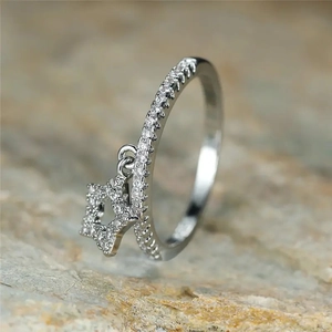 Macro shot of a silver star charm ring with shimmering cubic zirconia pavé stones