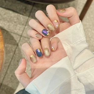 Handmade press-on nails with luxury French gold edges, purple glitter, and pearl details