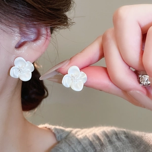 Detailed view of elegant white zircon flower stud earrings with a lustrous pearly finish