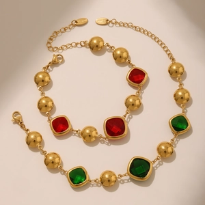 Gold-plated stainless steel jewelry set with red and emerald green faceted gemstones