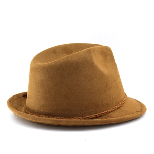 Detail of a brown suede cowboy hat with a stylish braided decorative band on a white background