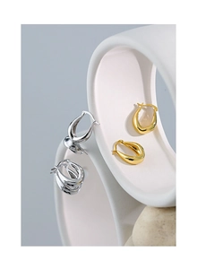 Macro detail of polished S925 sterling silver U-shaped earrings in gold and silver finish