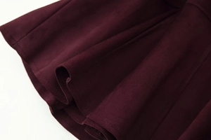 Macro shot of burgundy faux suede fabric showing soft texture and premium stitching