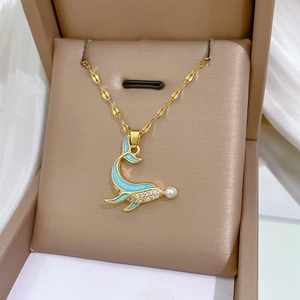Detailed close-up of a blue whale pendant necklace with pearls and zircon in a jewelry box